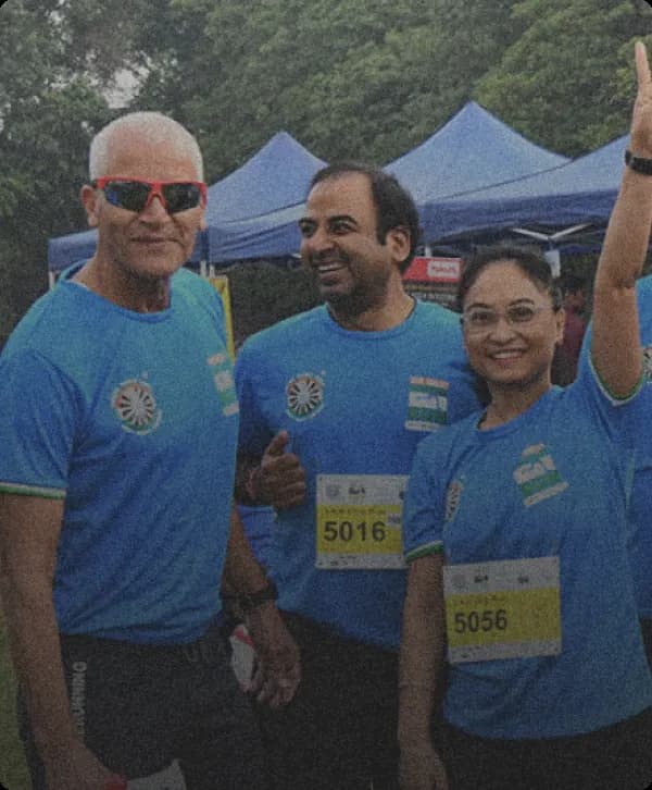 Three people in blue sportswear one with sunglasses and others with number Shirts.